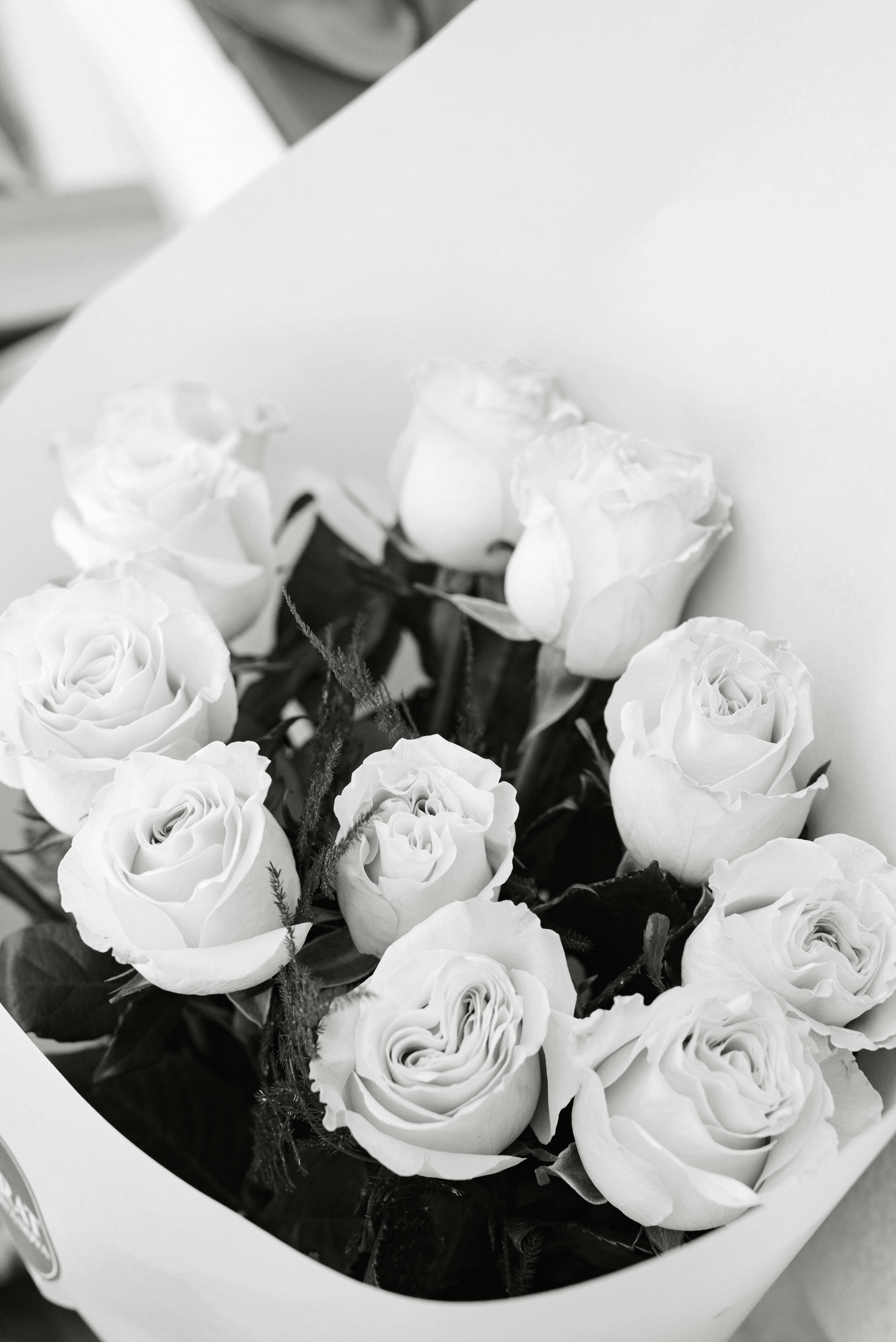 Black and white close-up of an elegant bouquet of roses, showcasing intricate floral details.