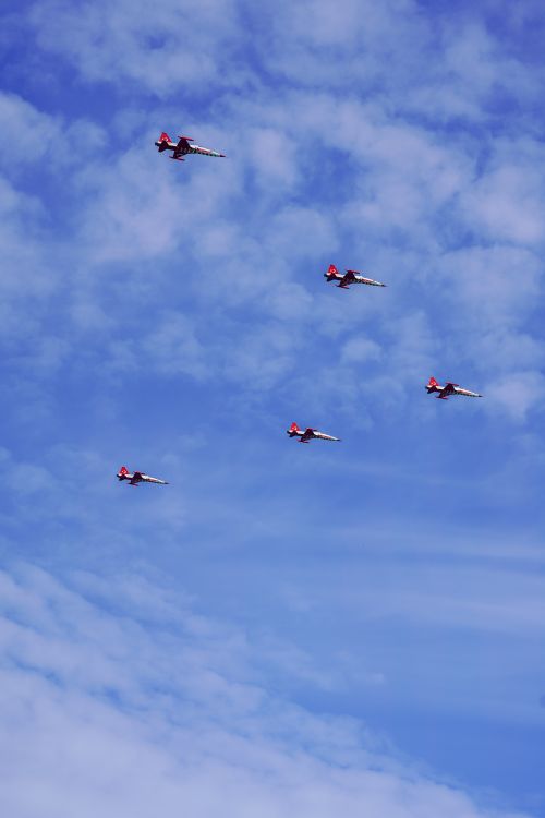 Free High-performance jets perform precision aerobatics against a stunning blue sky, captivating spectators below. Stock Photo