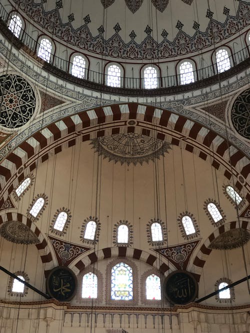 The inside of a mosque with arches and windows
