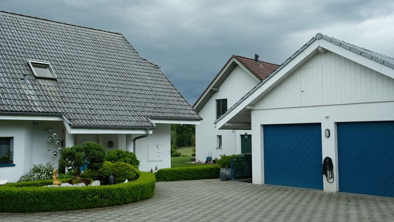 portable generator running on a driveway beside a house with a heavy-duty outdoor extension cord