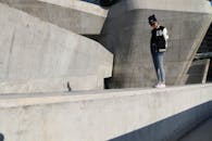 一位穿着休闲服的女人站在现代混凝土结构的户外，营造出城市氛围