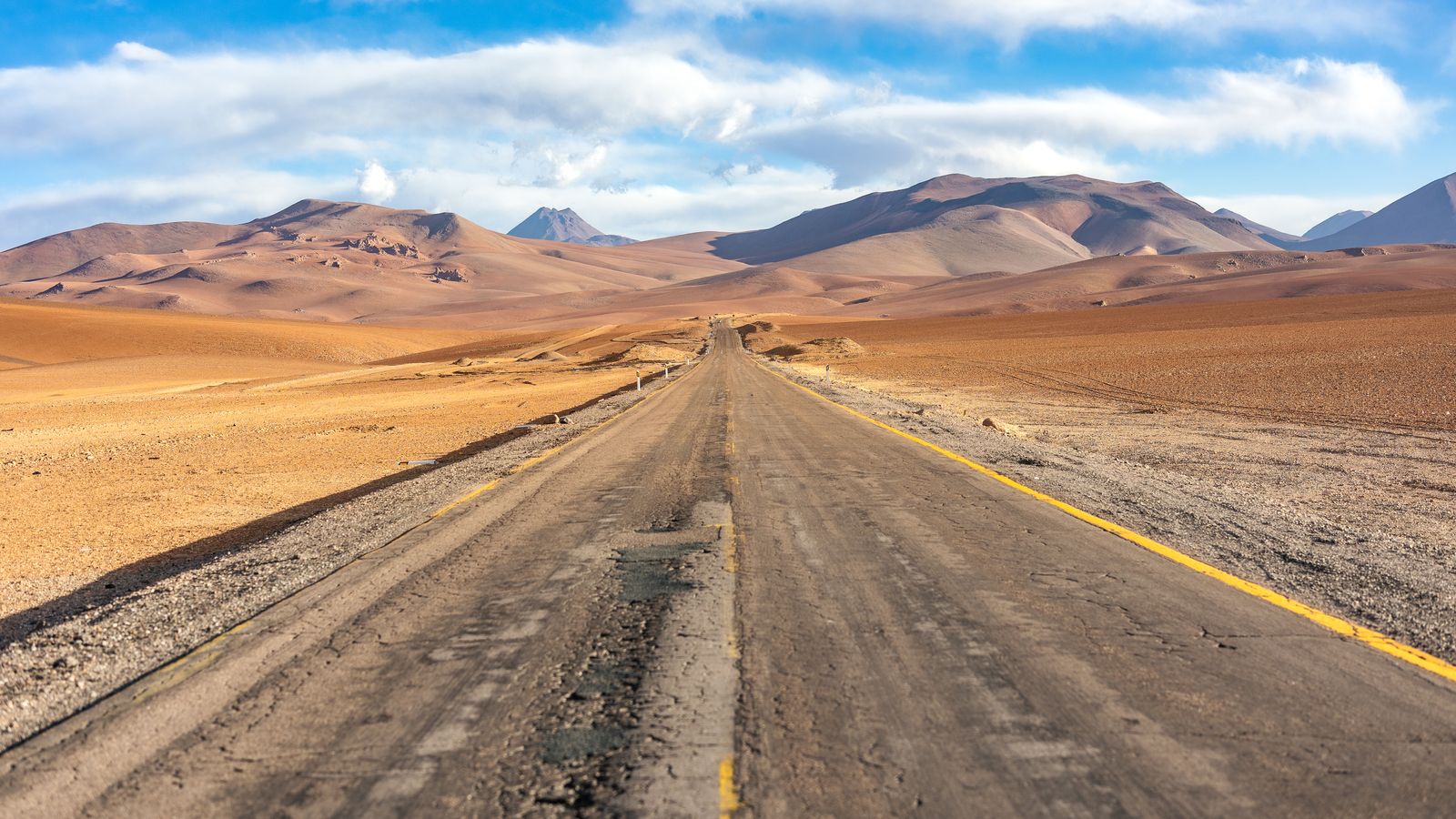 Long stretch of sun-baked desert highway with heat shimmer in the distance