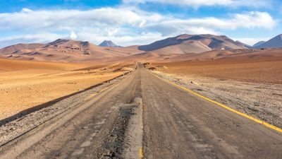 Long road through arid desert hills — photo by Marek Piwnicki on Pexels