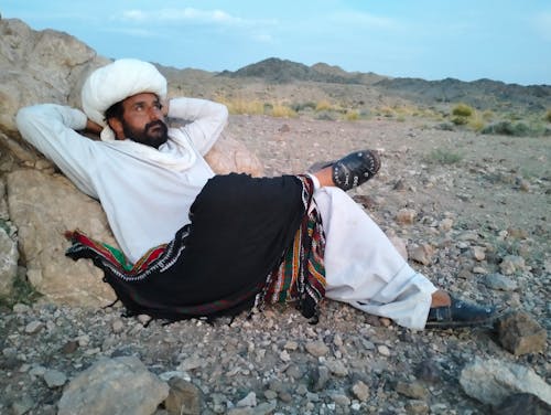 balochi culture dress with dastar background mountain sky