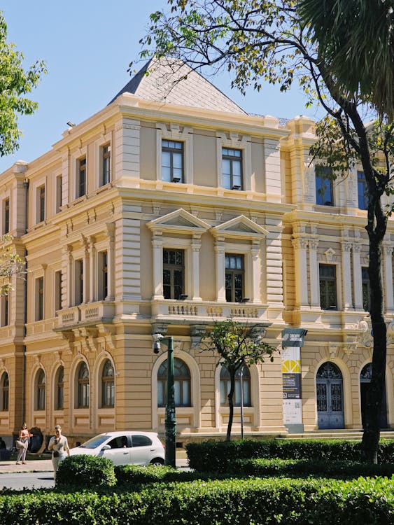 A large yellow building with cars parked in front