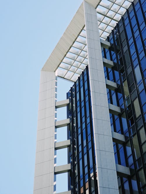 A tall building with glass windows and a blue sky