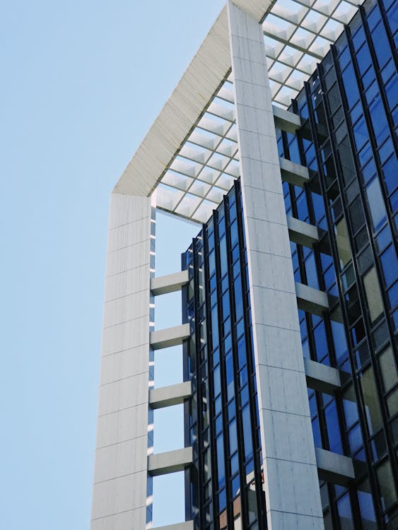 A tall building with glass windows and a blue sky