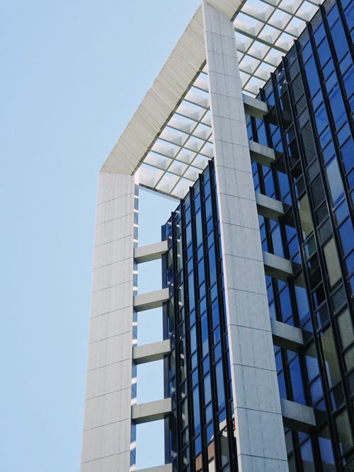 Free A stunning modern skyscraper with geometric design elements against a clear sky. Stock Photo