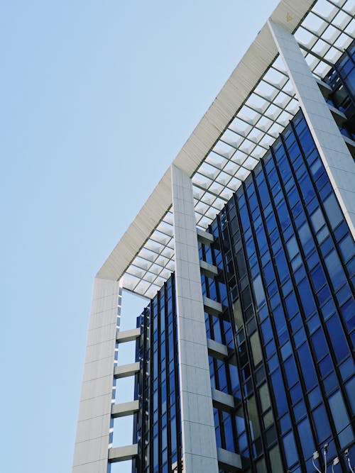 A tall building with glass windows and a blue sky