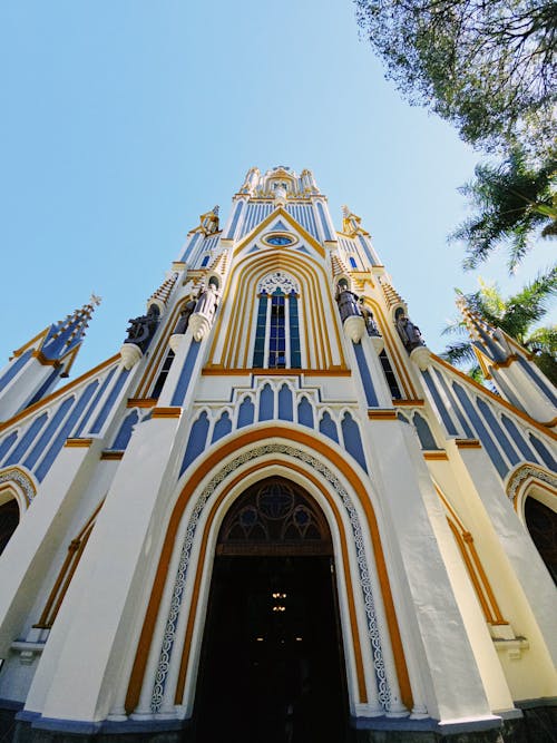 A tall white church with blue and yellow trim