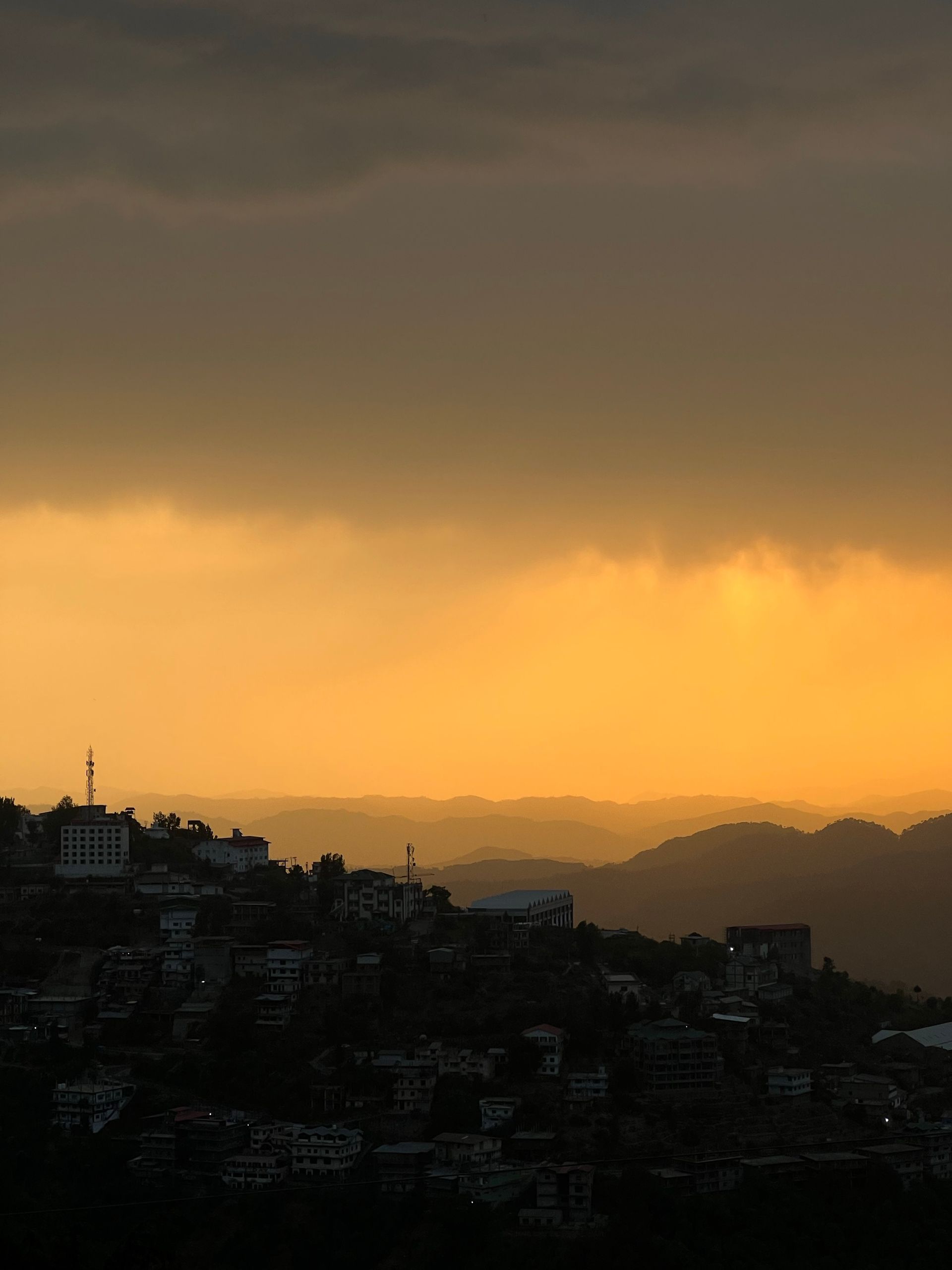 Breathtaking view of sunrise casting golden hues over the cityscape of Shimla, India.