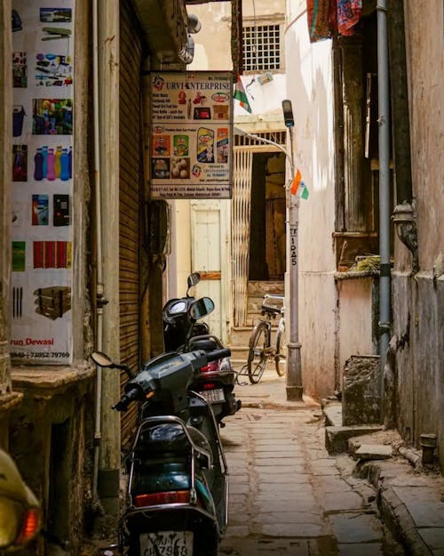 A narrow alley with a scooter parked in front of a building