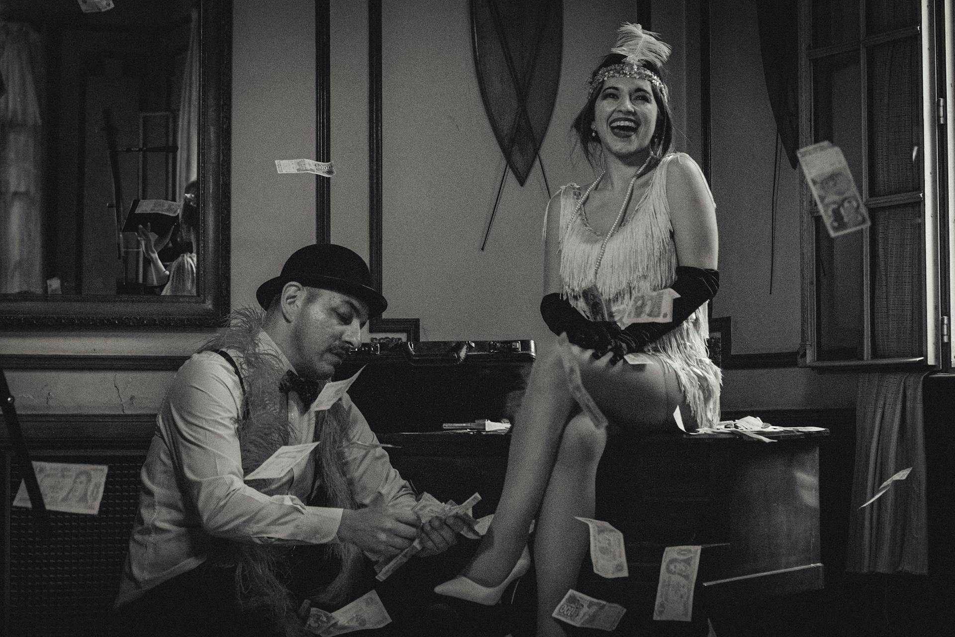 Vintage-themed black and white photo of a couple in a 1920s setting with money flying around.