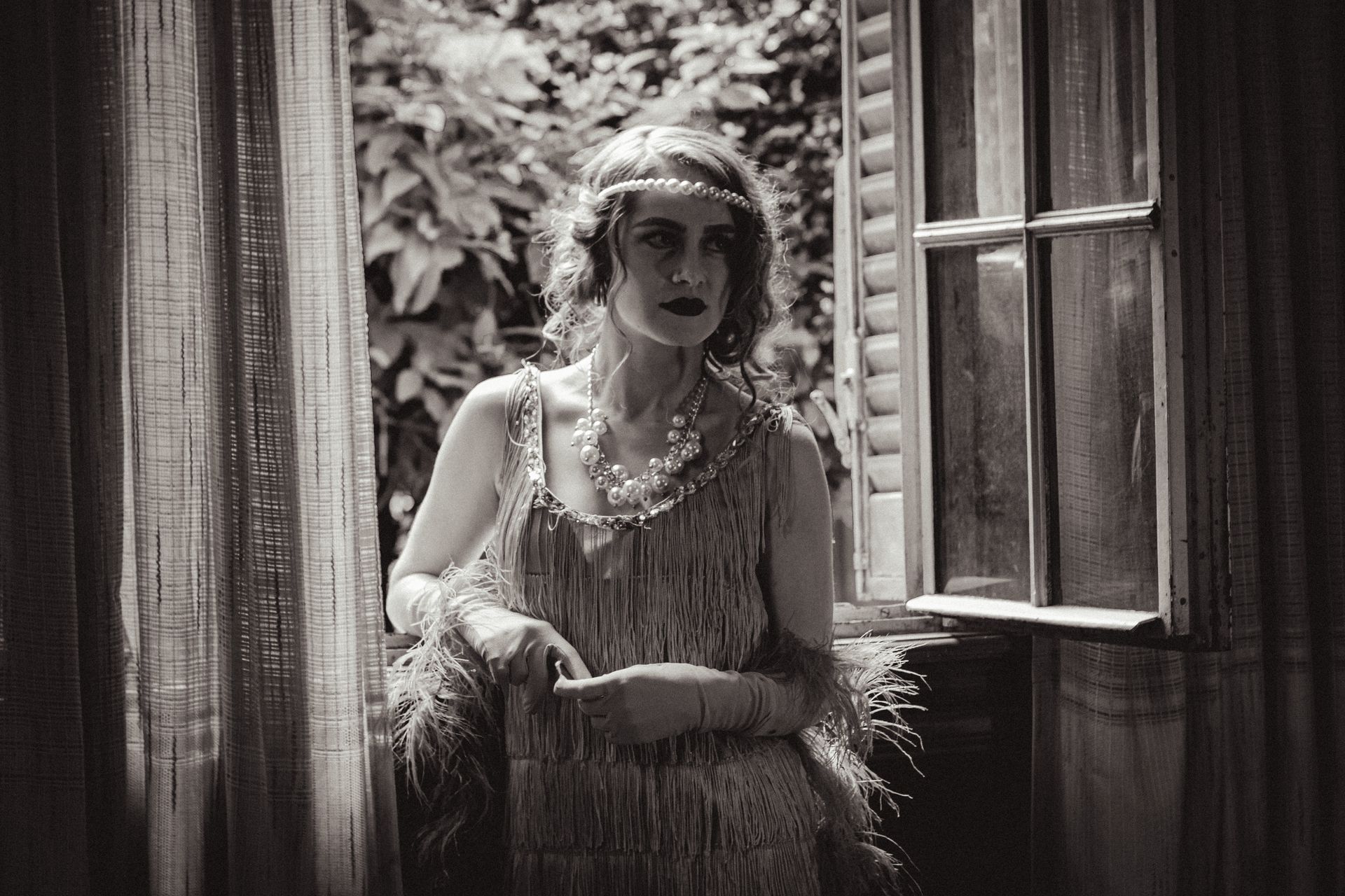 Woman in Flapper Dress Standing by Window