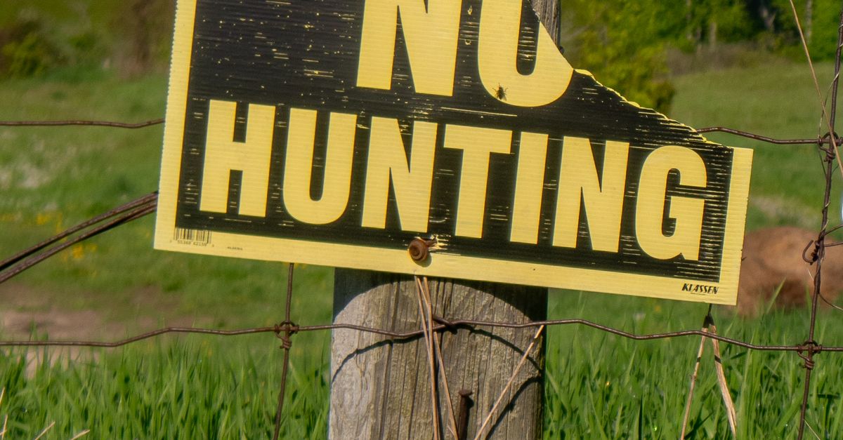No Hunting Warning Sign on Post on Field · Free Stock Photo