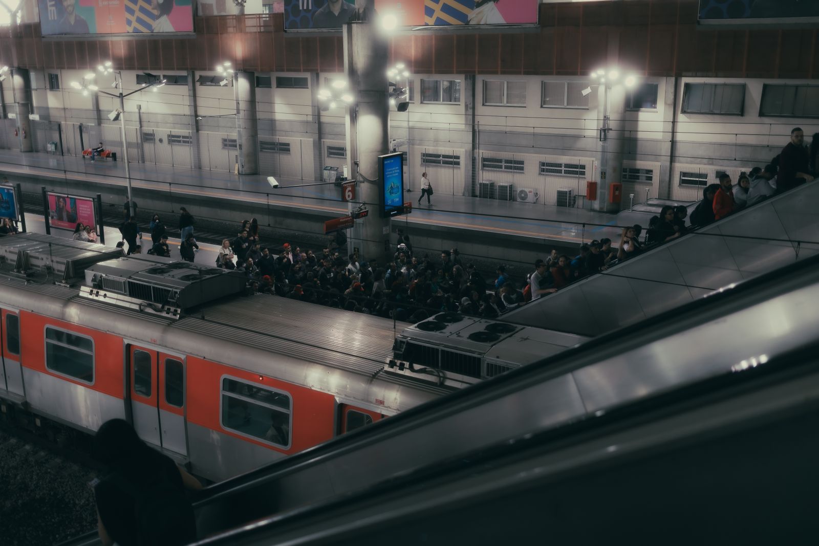 Passengers and train at a busy station during evening travel