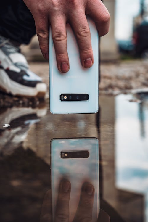Free Reflection of White Smartphone on Water Stock Photo