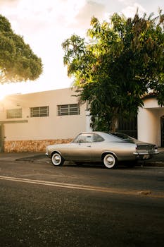 Classic Chevrolet Opala parked on a quiet street, bathed in sunset light, adding a vintage charm to the urban scene.