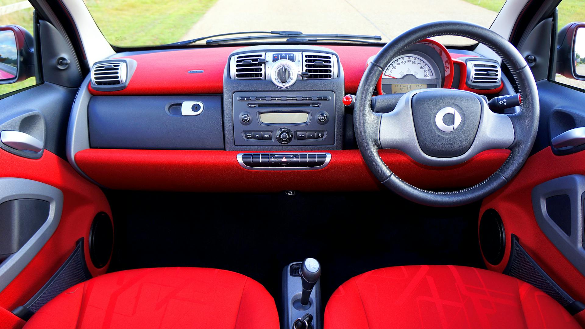 A luxury car interior showcasing a modern dashboard with red detailing, perfect for driving enthusiasts.