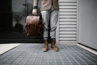 Leather backpack held outdoors, photo by Andrew Neel on Pexels