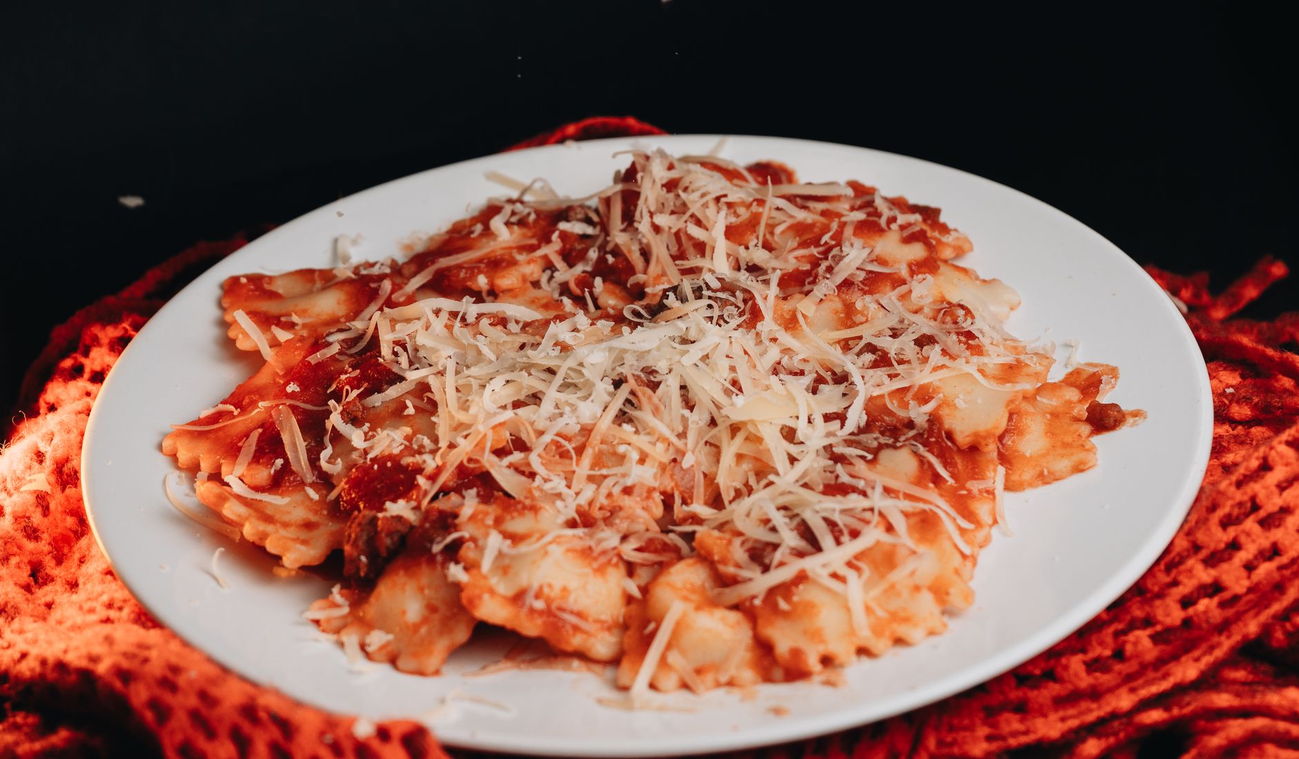 Baked ravioli covered with melted cheese and fresh basil