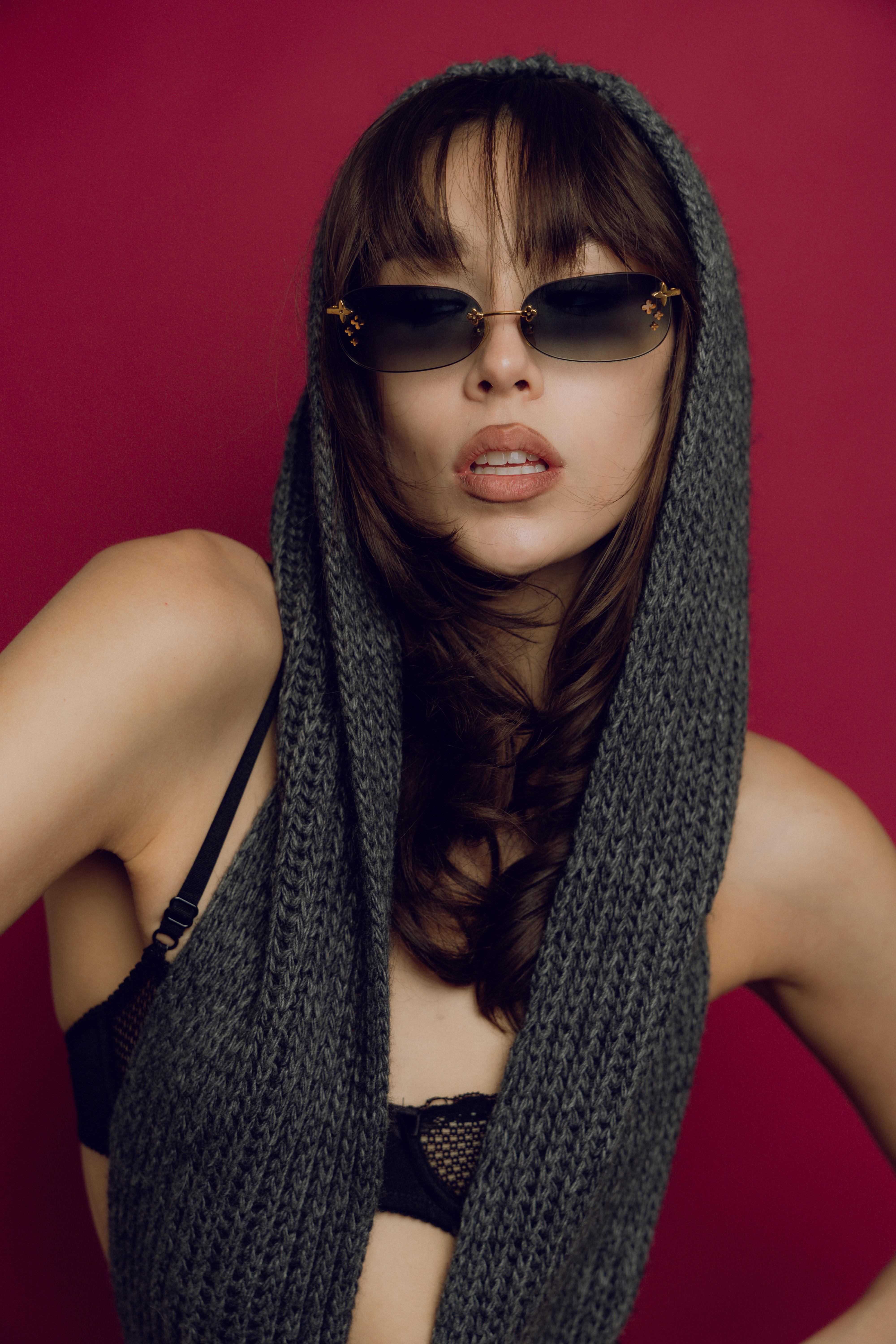 a woman in a scarf and sunglasses posing for a photo