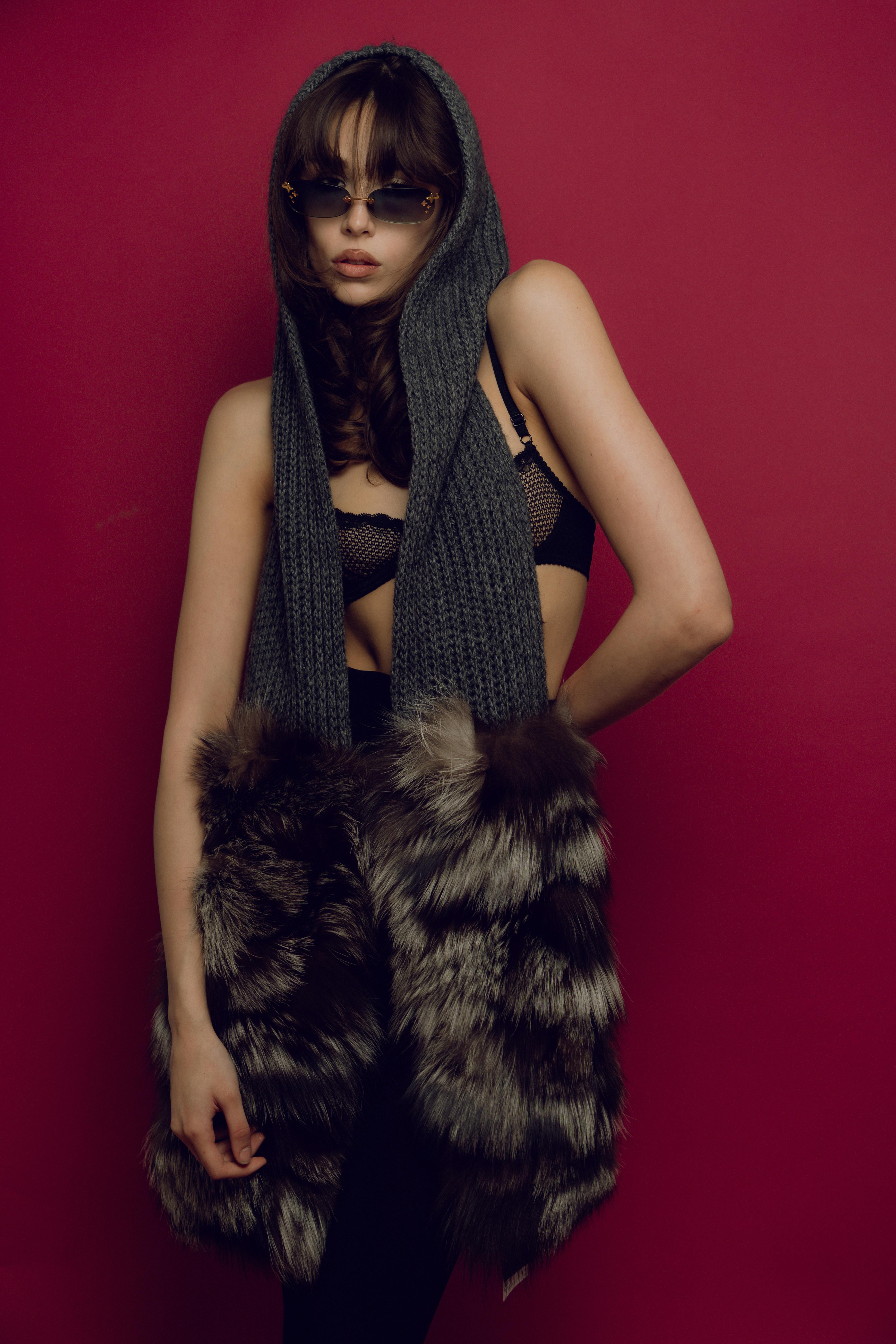 a woman in a fur coat and glasses posing for a photo