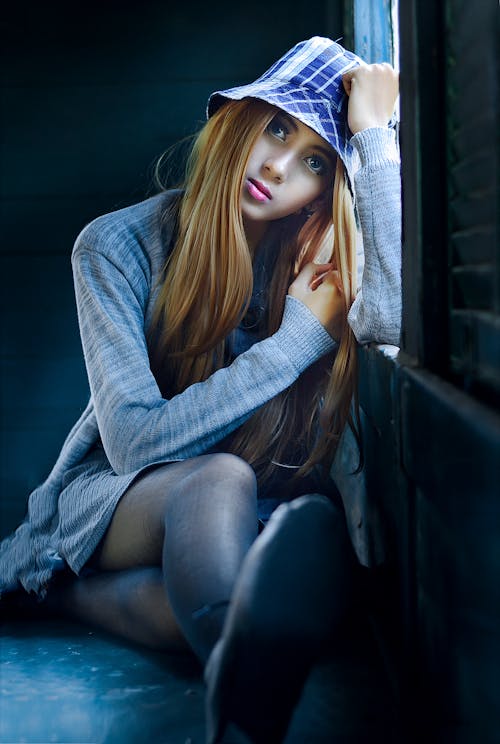 Free Woman Wearing Heather-gray Cardigan Leaning on Window Stock Photo