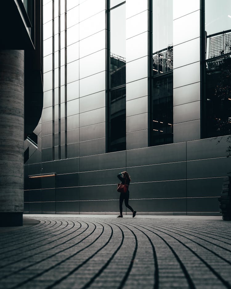 Low Angle Shot Of Woman Walking Beside Building