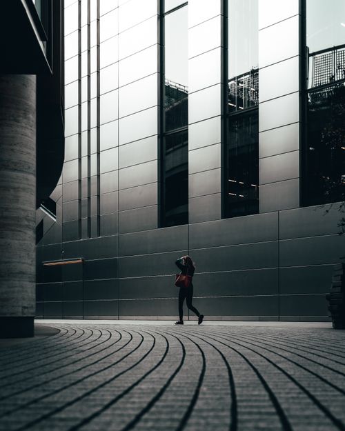 Free A person walks along a modern architectural passageway in London, England. Stock Photo