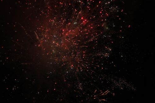 Free Vibrant fireworks illuminating the dark sky with bursts of red and white light. Stock Photo