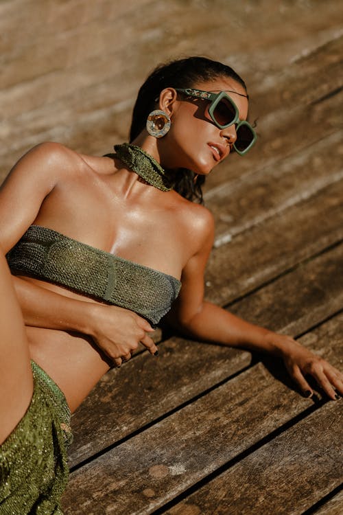 A woman in a green bikini and sunglasses