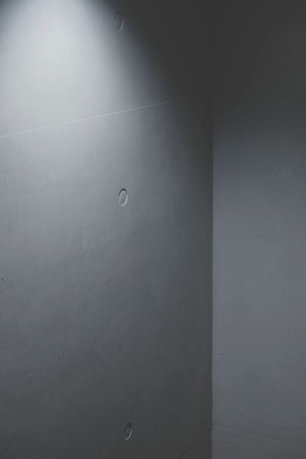 A minimalist concrete wall featuring soft lighting creates an abstract and modern atmosphere.