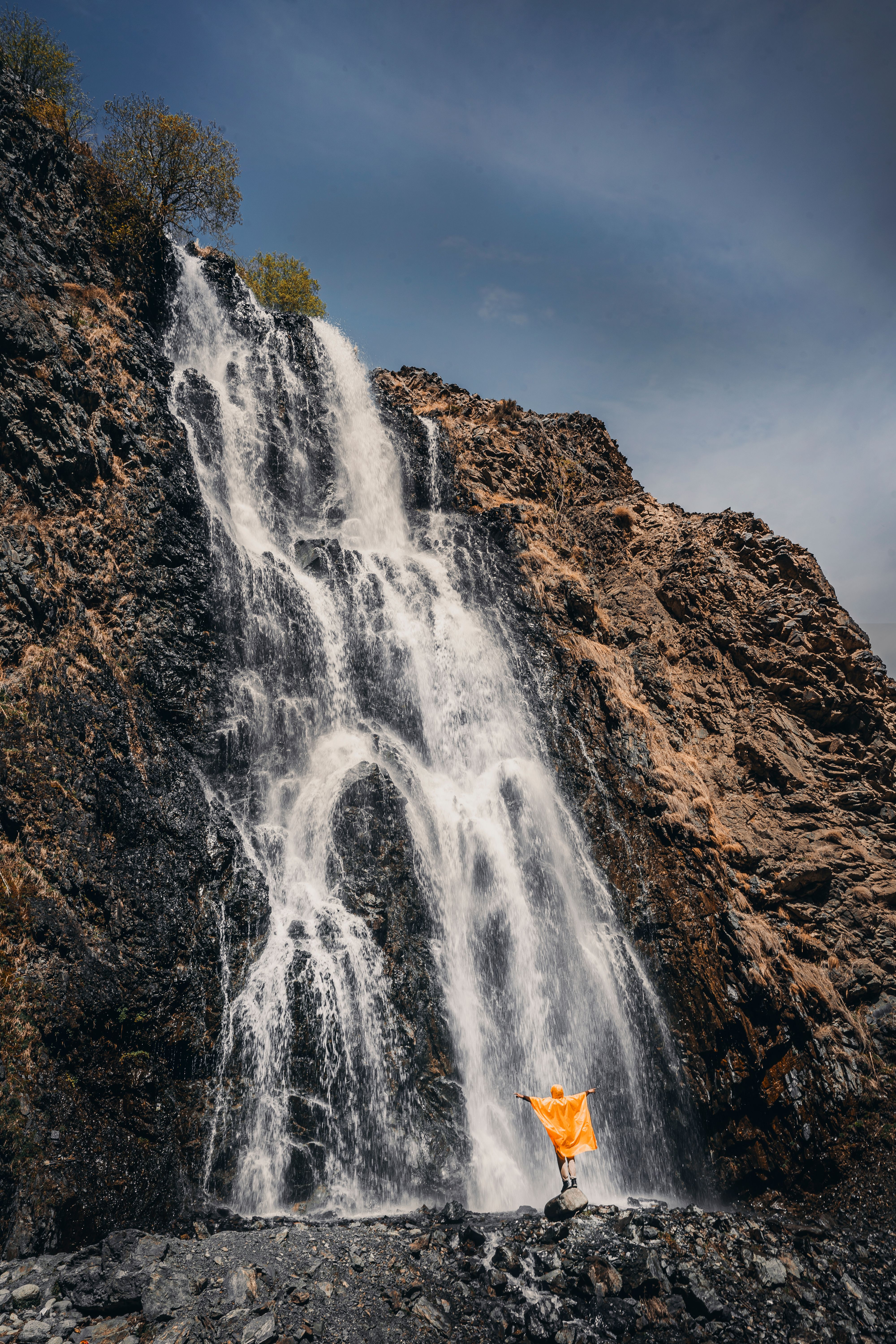 A person standing in front of a waterfall · Free Stock Photo
