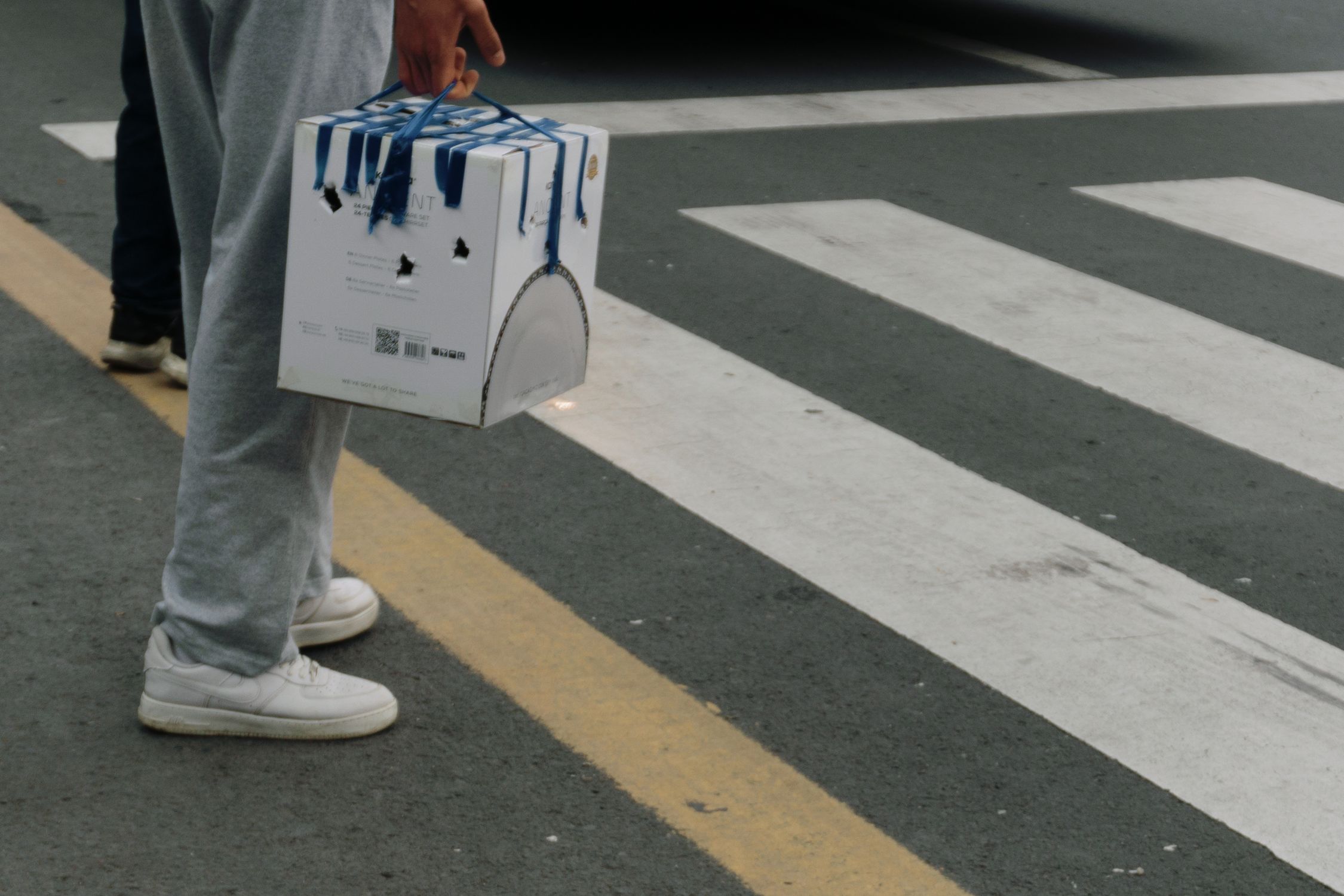 A person carrying a box on the street · Free Stock Photo