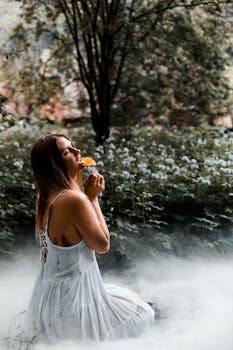 一名女子身穿白色连衣裙，在梦幻般的雾气森林中捧着鲜花