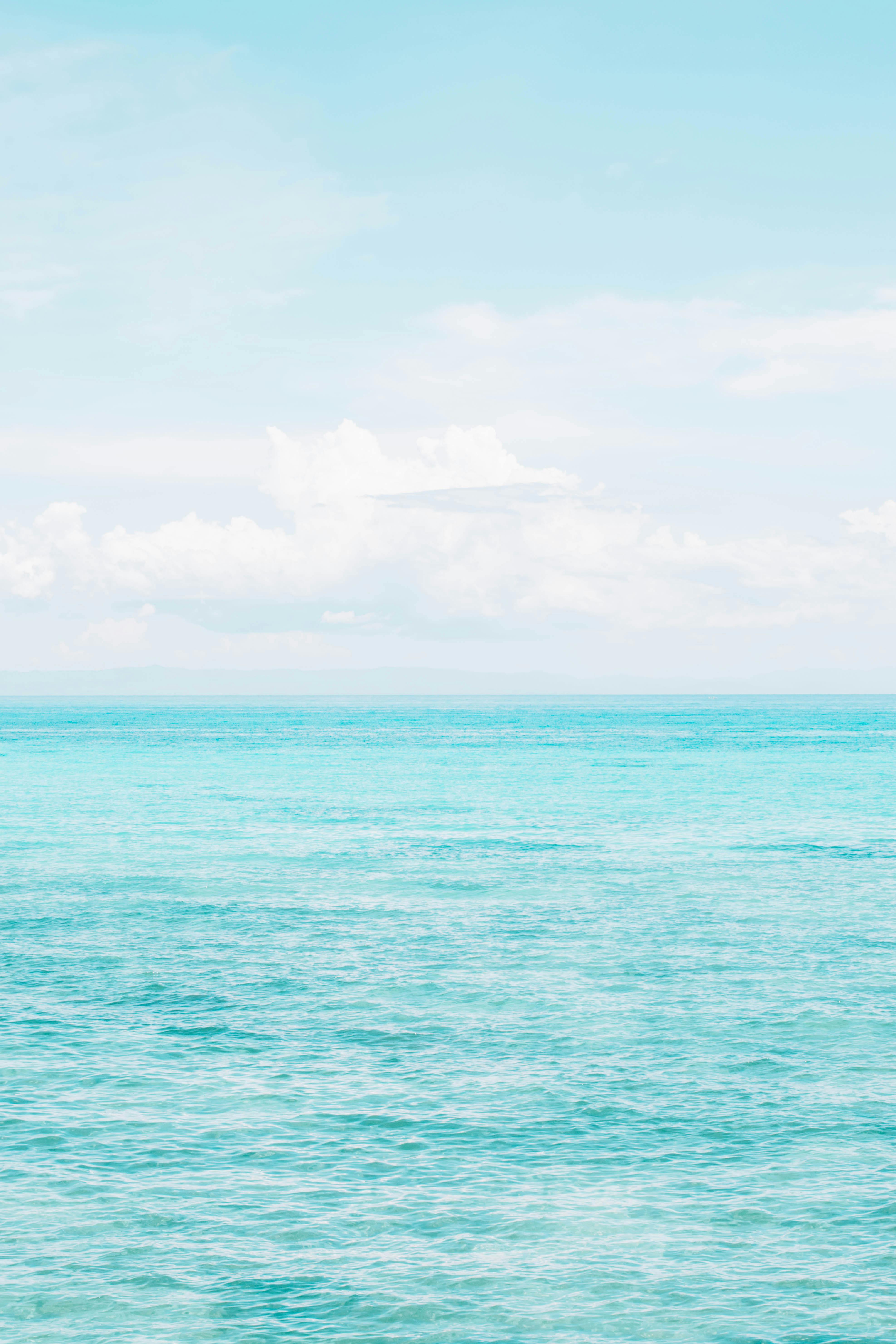 A serene scene of turquoise water meeting a clear sky, perfect for beach-themed projects.