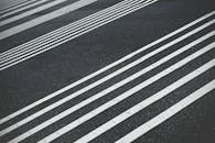 极简主义设计下的抽象视图：黑色沥青上平行排列的白色道路标记