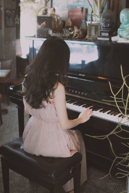 A woman playing the piano in a living room