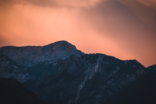 A sunset over a mountain range with clouds