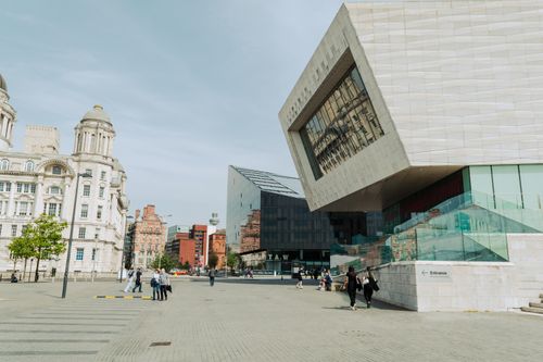 Free View of modern and historical architecture in Liverpool, England with pedestrians in a city square. Stock Photo