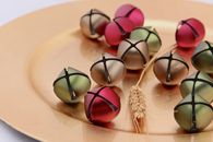 Colorful jingle bells on a gold plate, perfect for holiday decoration imagery.