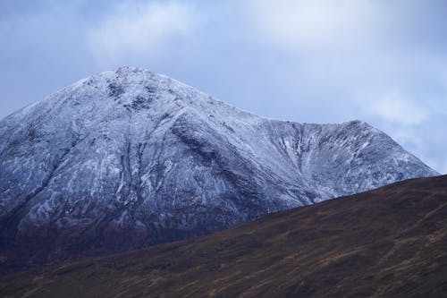 A snow covered mountain with a large snow covered peak
