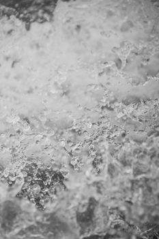 Abstract black and white close-up of dynamic water splash, frozen in motion.