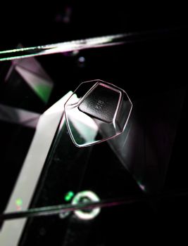 Close-up of a glass guitar pick with reflections, highlighting its modern, elegant design.