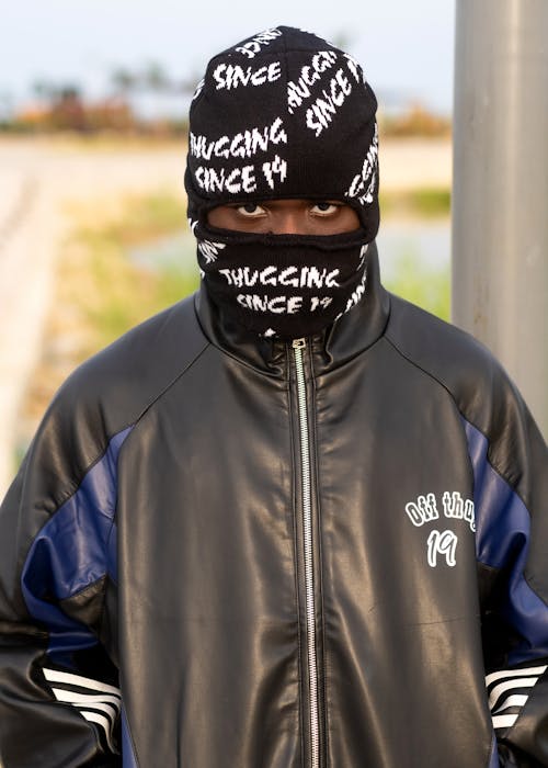 A man wearing a mask and jacket with the words'suckin'