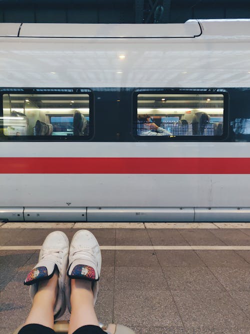 Foto Der Person, Die Auf Dem Boden Nahe Zug Sitzt