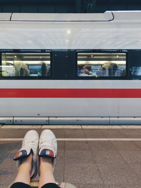 Photo of Person Sitting on Floor Near Train