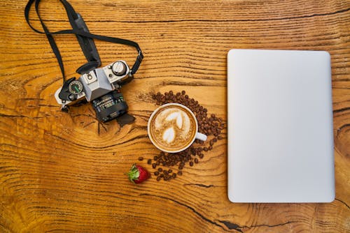 Free Latte Coffee And Camera On Wooden Surface Stock Photo