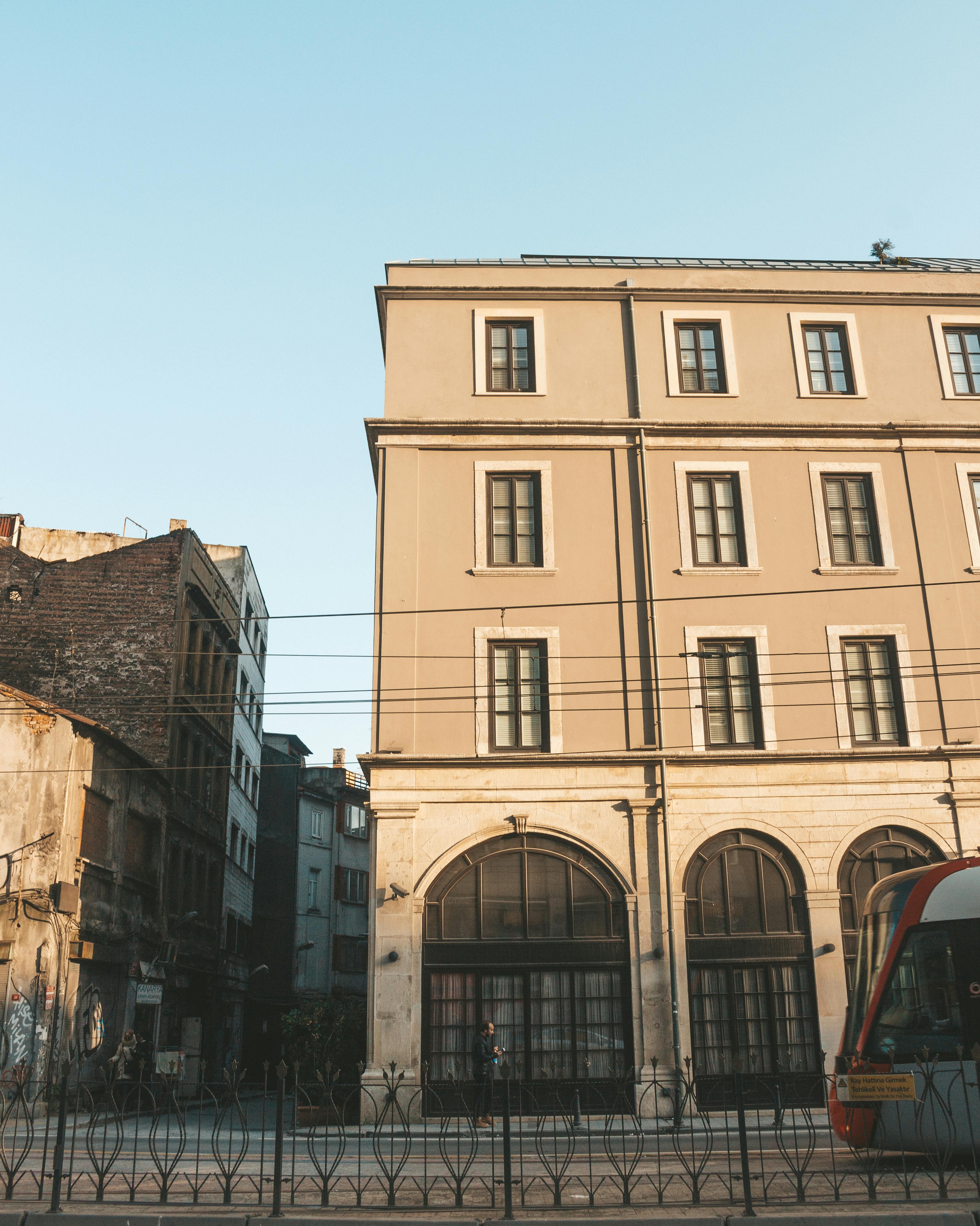 日落时分，电车驶过一座历史建筑，街景捕捉着城市建筑的永恒魅力